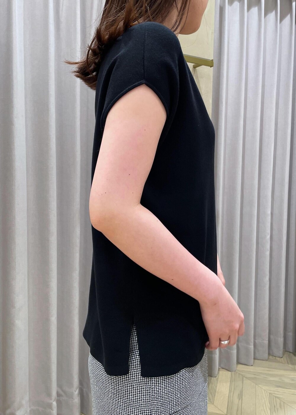 ベージュ系のハンドバッグ、シルバー系のパンプス、ブラック系のニット/セーターを着用したレディースの春コーディネートの5枚目の写真