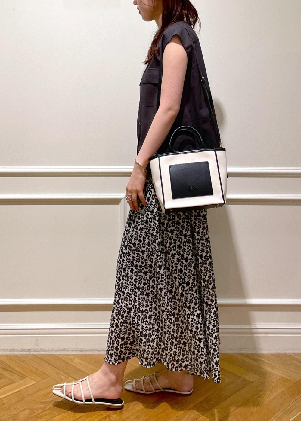 ホワイト系のサンダル、ブラック系のトートバッグ、ブラウン系のシャツ/ブラウスを着用したレディースの夏コーディネートの3枚目の写真