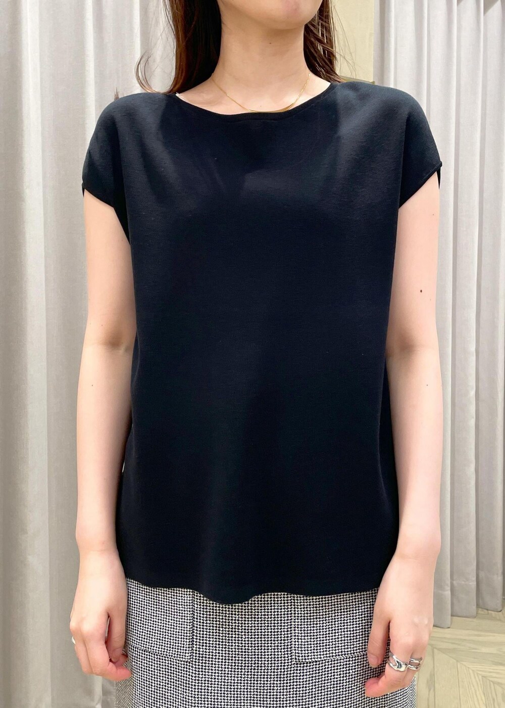 ベージュ系のハンドバッグ、シルバー系のパンプス、ブラック系のニット/セーターを着用したレディースの春コーディネートの4枚目の写真