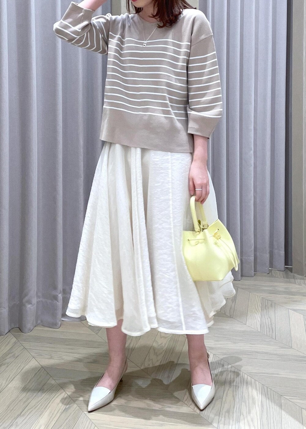 「バッグ、イエロー、ベージュ、ボーダー、otonaMUSE、ROPÉ、24SS春の新作、ブルベ、高身長、骨格ウェーブ、フェミニン、ニット、スカート、フレアスカート、パンプス」｜「ROPE'のアナグラムモチーフドロストミニバッグ（ハンドバッグ、ベージュ系）」を使った、RAIさん（レディース・165cm）の春コーディネートの4枚目の写真