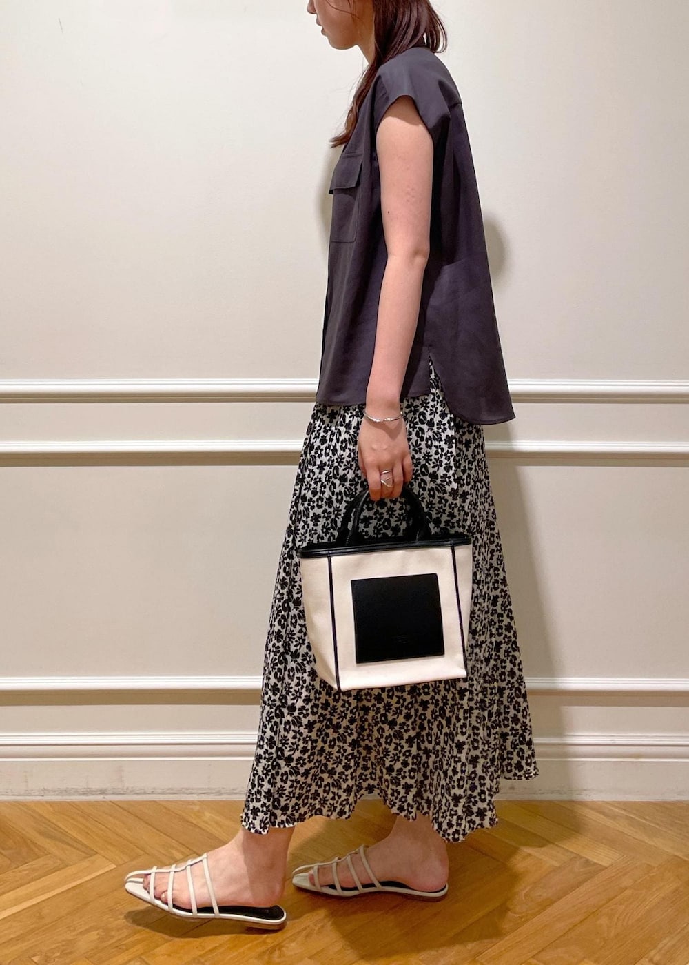 ホワイト系のサンダル、ブラック系のトートバッグ、ブラウン系のシャツ/ブラウスを着用したレディースの夏コーディネートの2枚目の写真