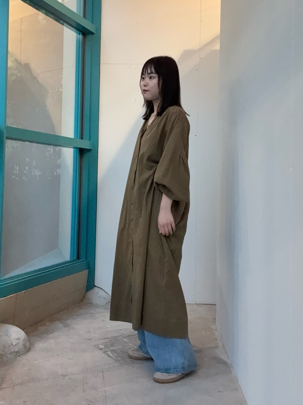 グリーン系のワンピースを着用したレディースの秋コーディネートの2枚目の写真