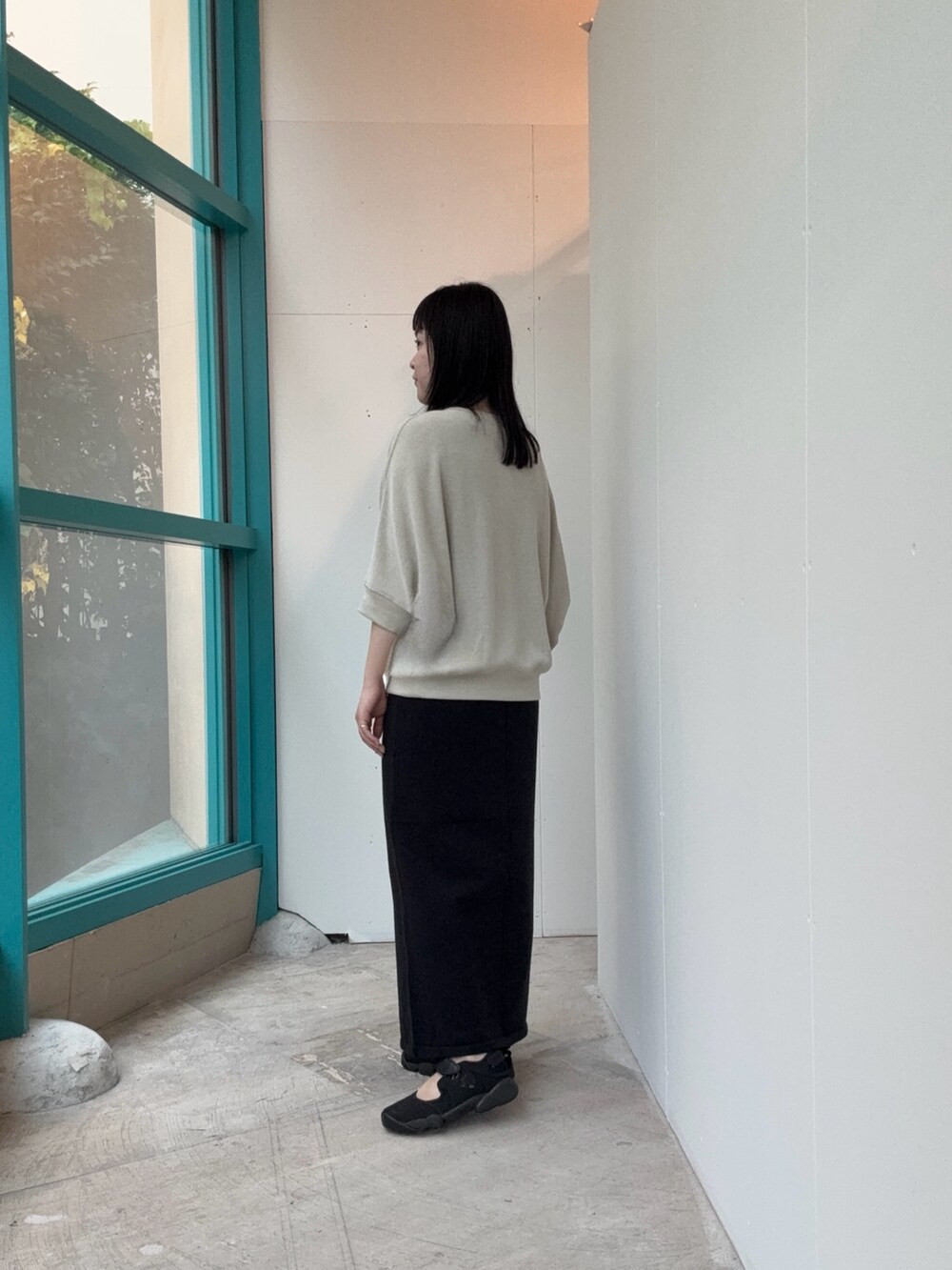 ベージュ系のTシャツ/カットソー、ブラック系のスカートを着用したレディースの秋コーディネートの3枚目の写真