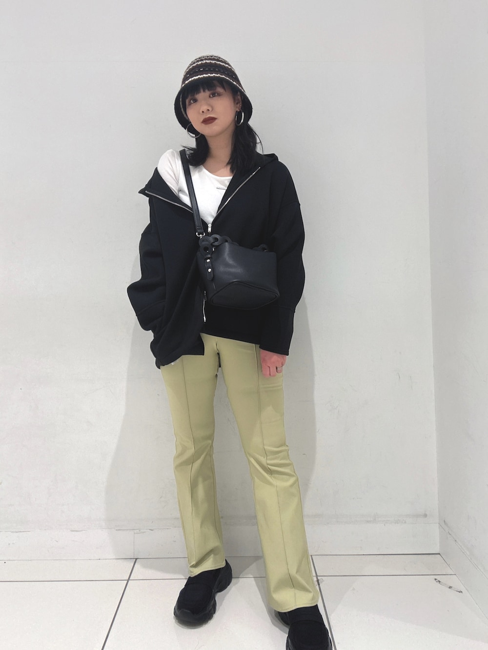 ブラック系のパーカー、ブラック系のショルダーバッグ、ホワイト系のTシャツ/カットソーを着用したレディースの冬コーディネートの2枚目の写真