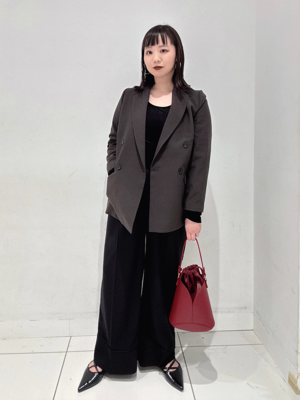 ブラウン系のその他アウター、ブラック系のその他パンツ、レッド系のハンドバッグを着用したレディースの秋コーディネートの3枚目の写真