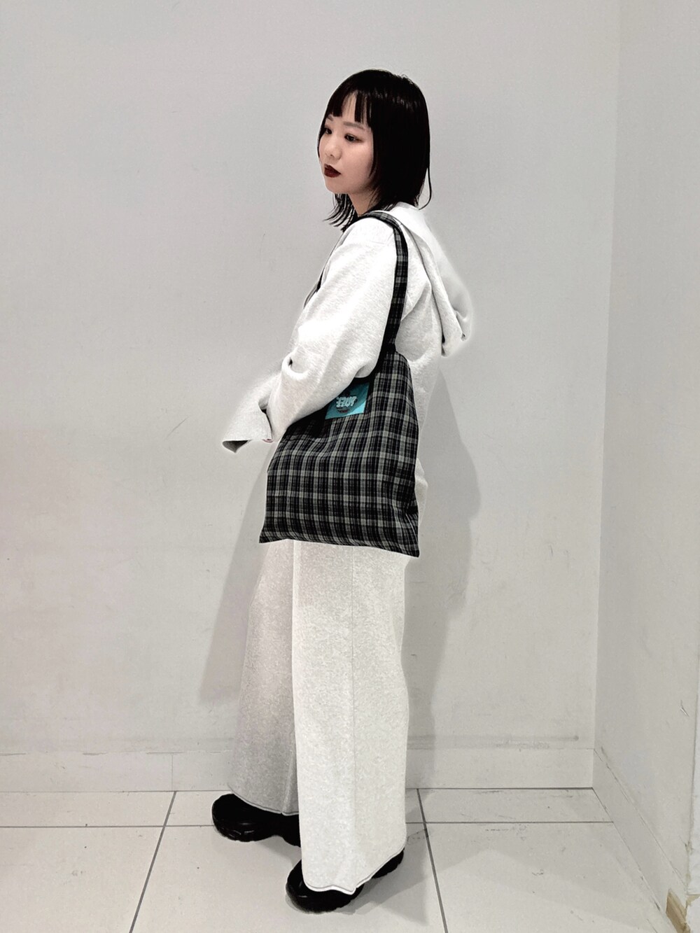 グレー系のパーカー、グレー系のスウェットパンツ、ブルー系のトートバッグを着用したレディースの秋コーディネートの3枚目の写真