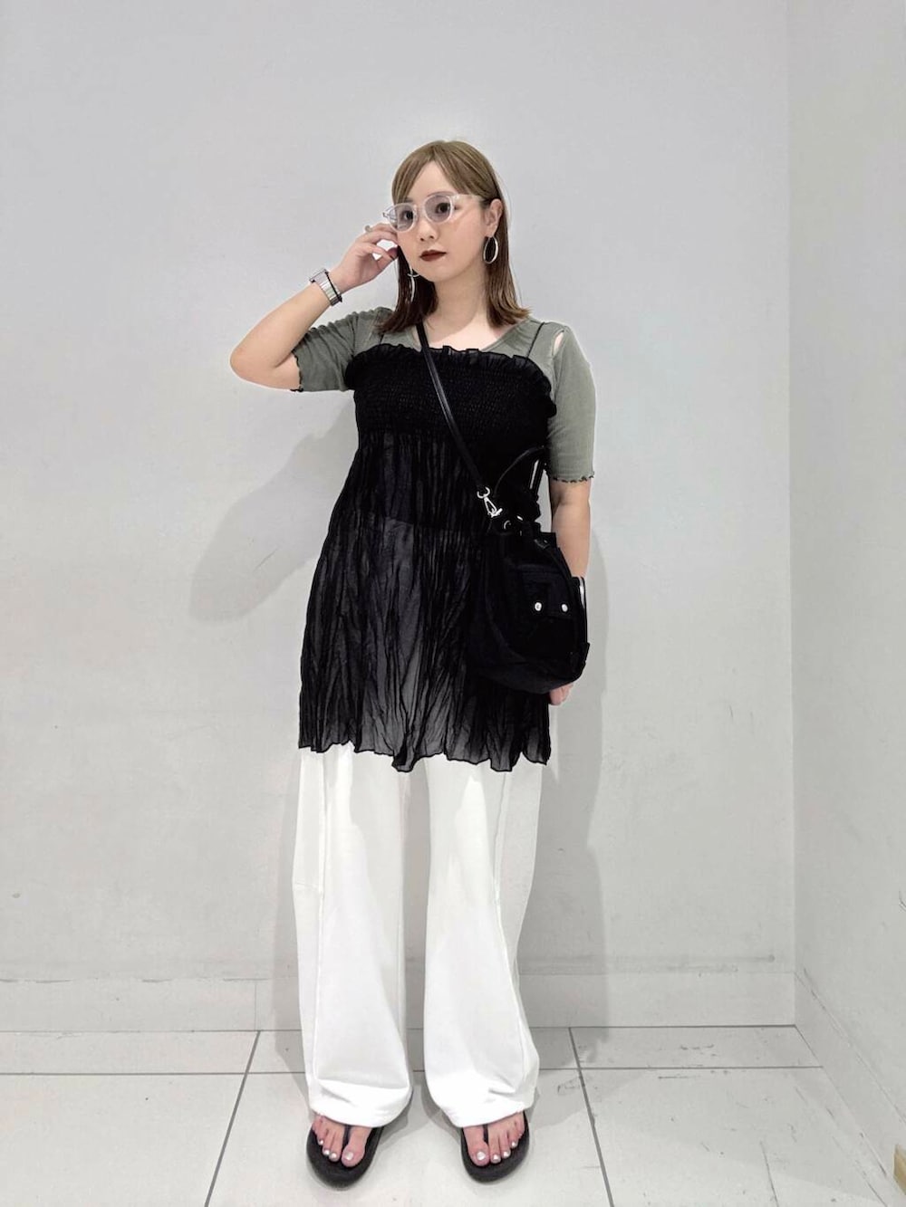 ブラック系のショルダーバッグ、グリーン系のTシャツ/カットソー、ホワイト系のその他パンツを着用したレディースの夏コーディネートの3枚目の写真