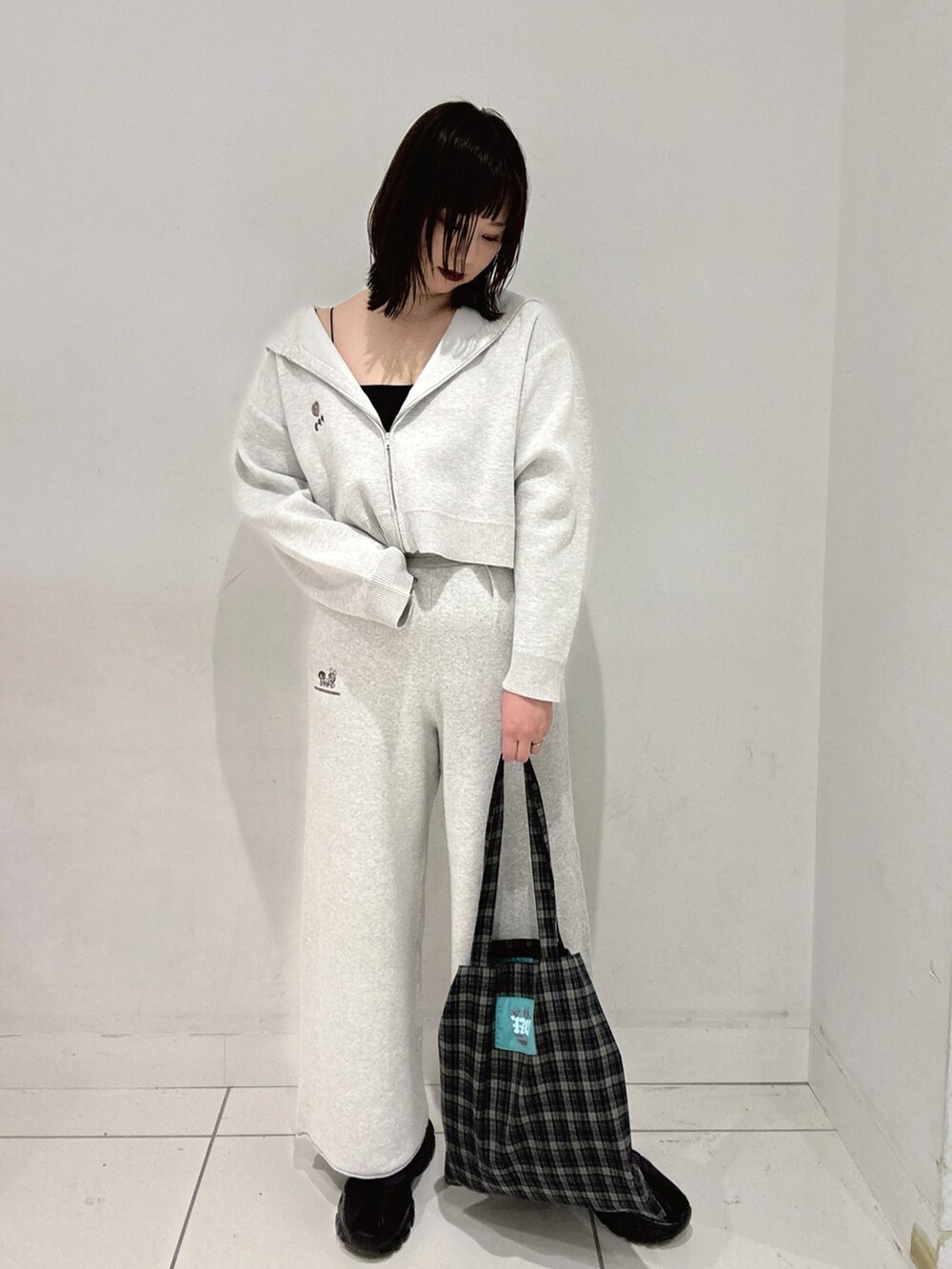 グレー系のパーカー、グレー系のスウェットパンツ、ブルー系のトートバッグを着用したレディースの秋コーディネートの2枚目の写真