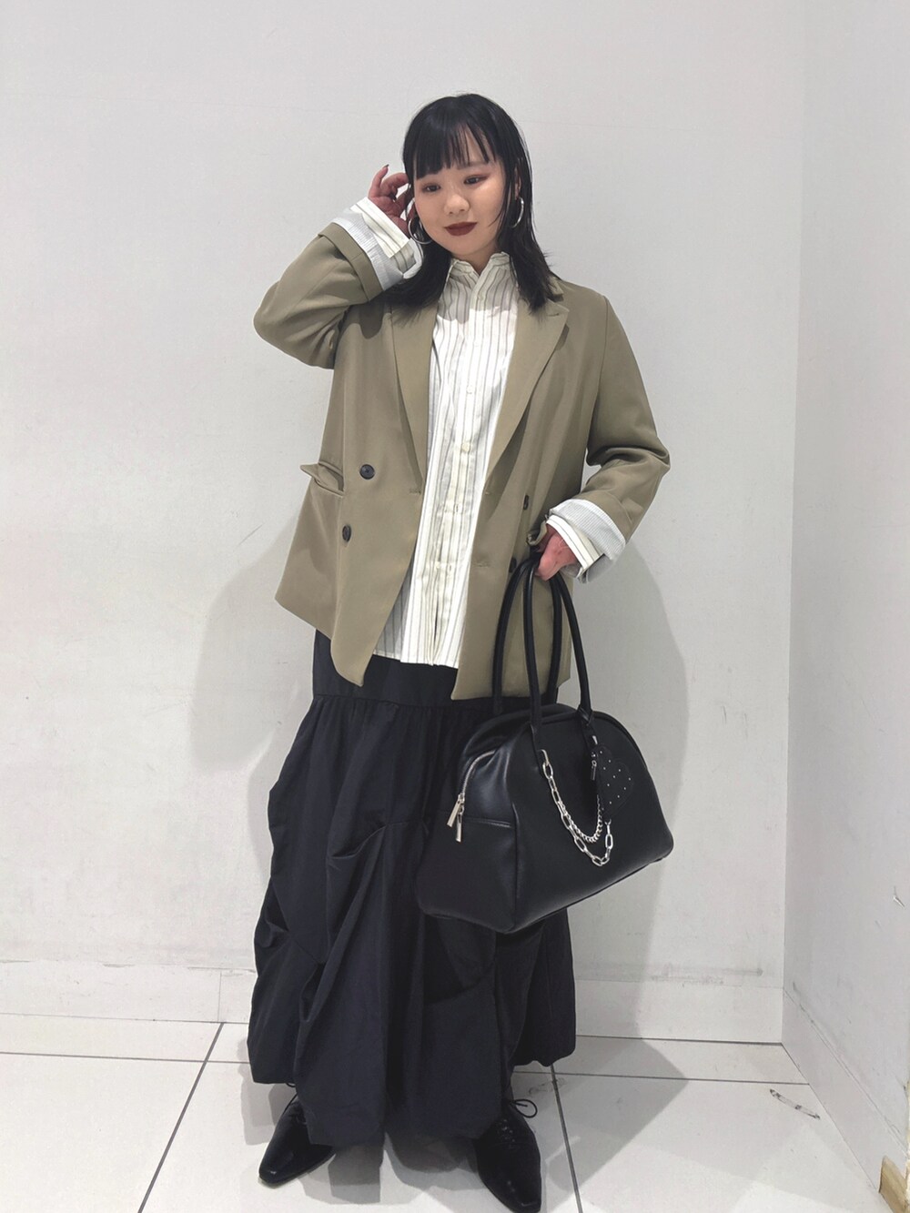 ベージュ系のテーラードジャケット、ホワイト系のシャツ/ブラウス、グレー系のスカートを着用したレディースの冬コーディネートの2枚目の写真