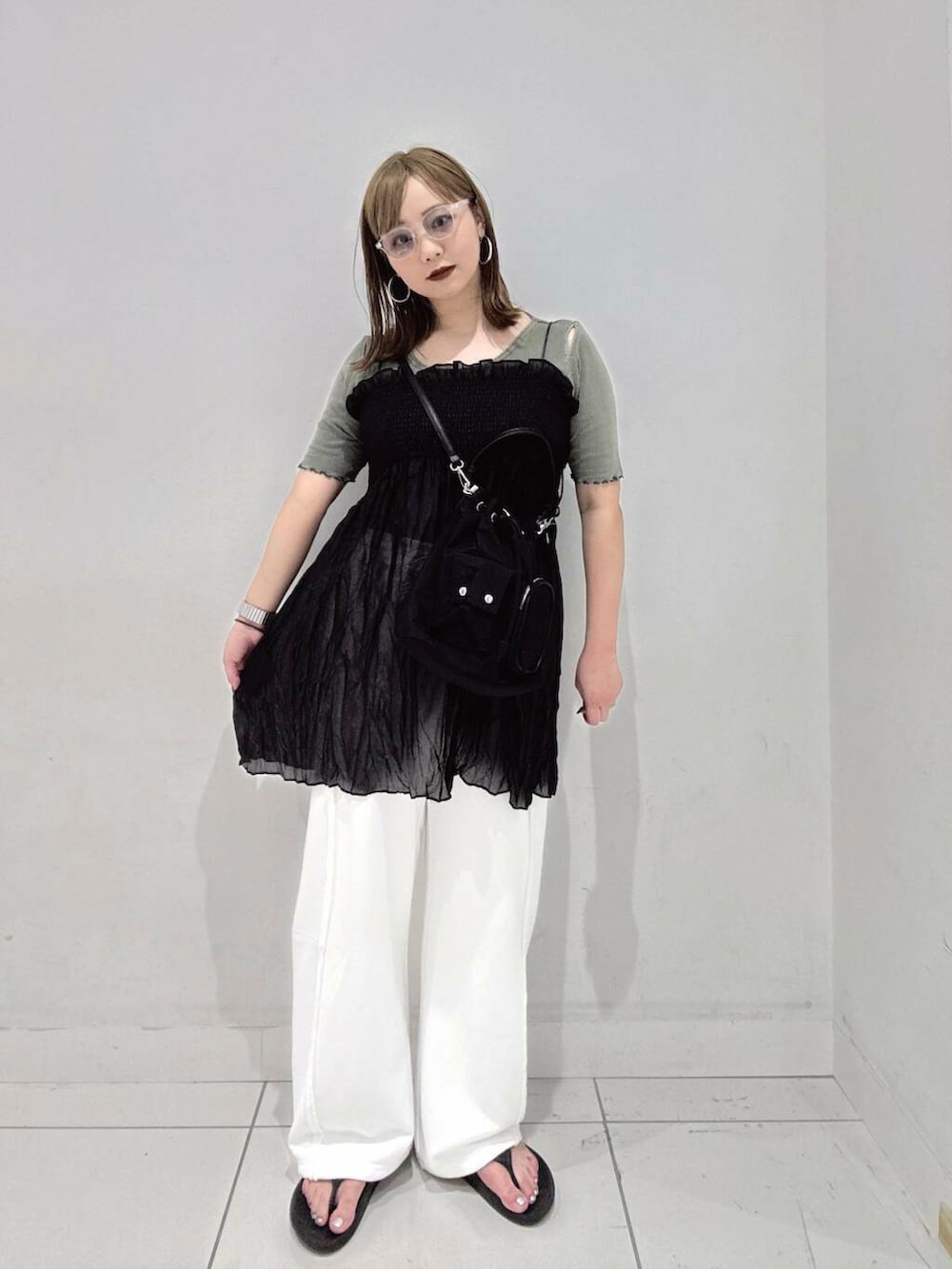 ブラック系のショルダーバッグ、グリーン系のTシャツ/カットソー、ホワイト系のその他パンツを着用したレディースの夏コーディネートの2枚目の写真