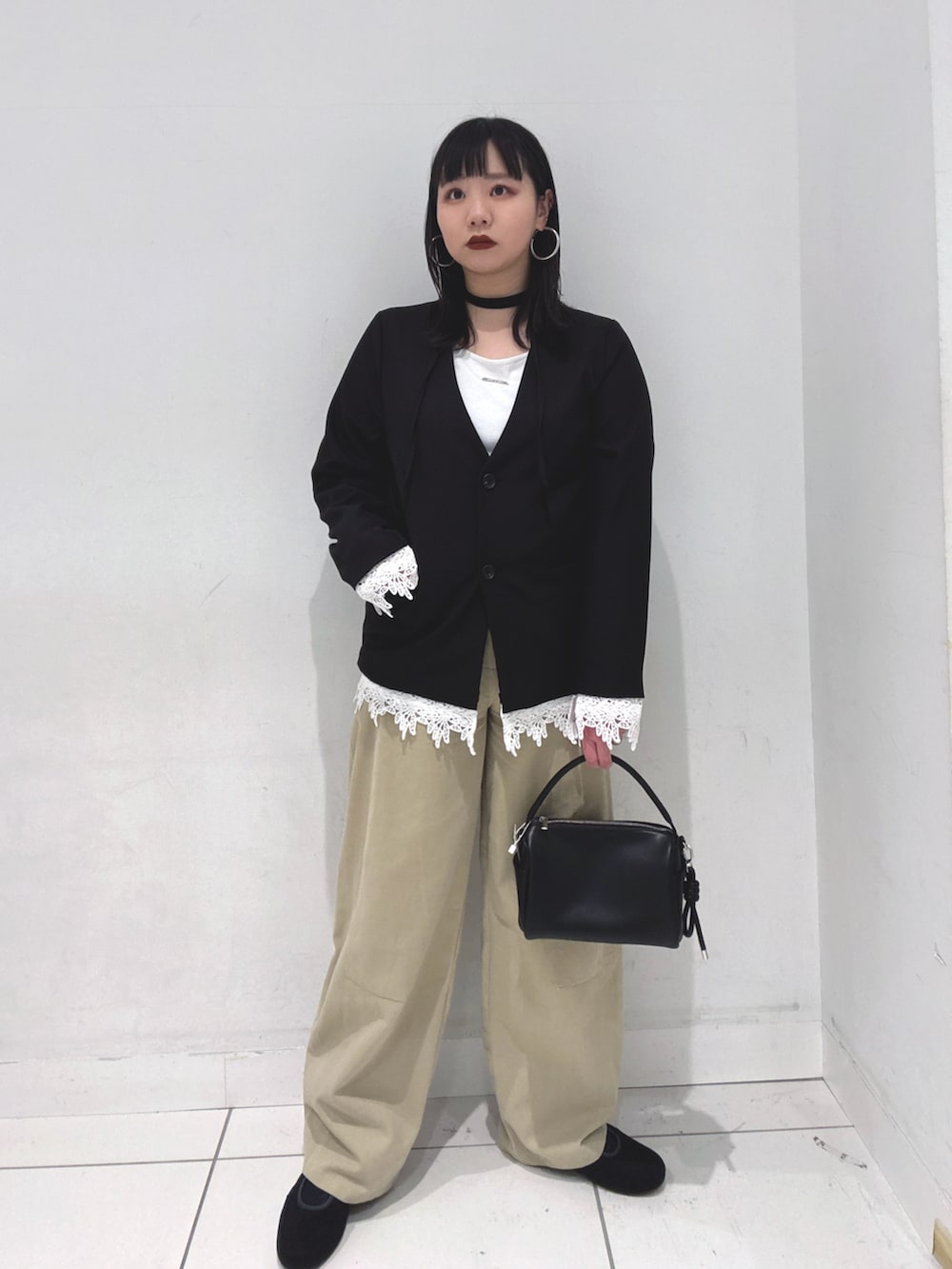 ブラック系のノーカラージャケット、ホワイト系のTシャツ/カットソー、ブラック系のハンドバッグを着用したレディースの冬コーディネートの4枚目の写真