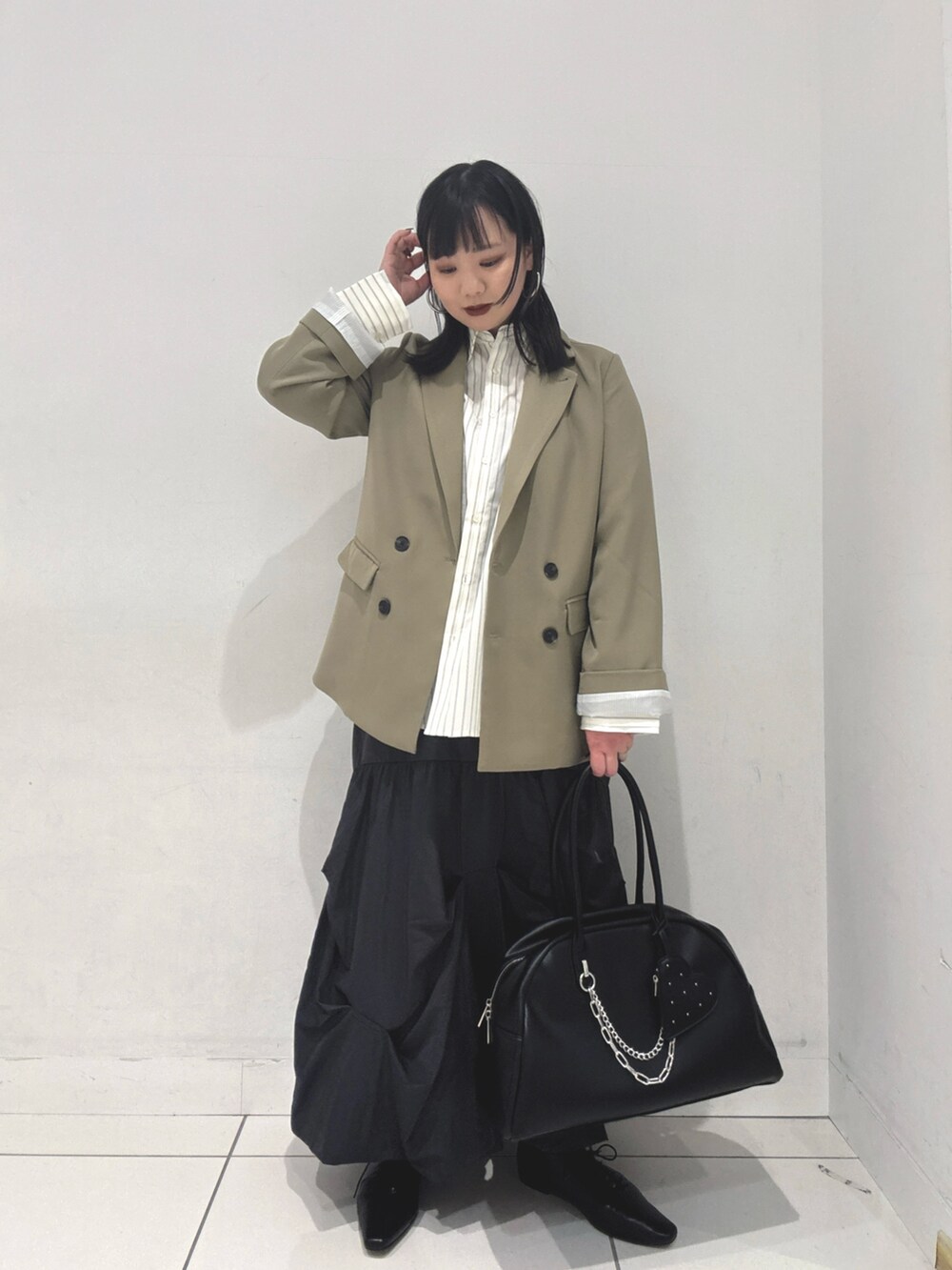 ベージュ系のテーラードジャケット、ホワイト系のシャツ/ブラウス、グレー系のスカートを着用したレディースの冬コーディネートの3枚目の写真