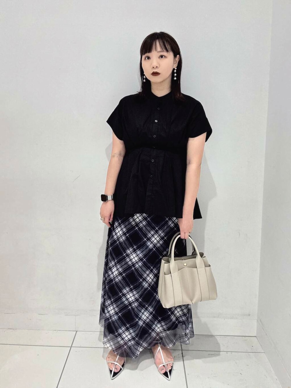 ホワイト系のトートバッグ、シルバー系のサンダル、ブラック系のシャツ/ブラウスを着用したレディースの夏コーディネートの3枚目の写真