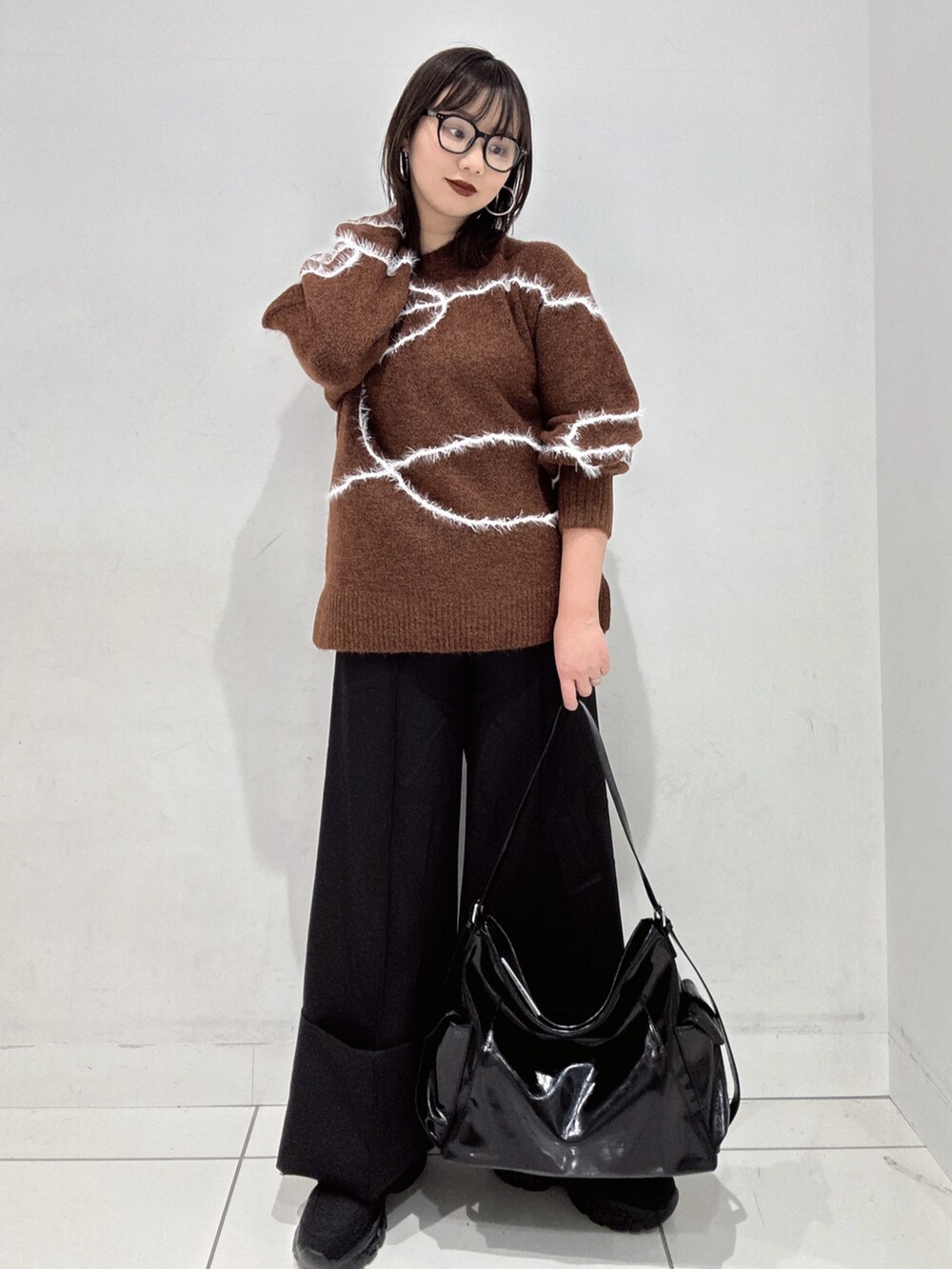 ブラウン系のニット/セーター、ブラック系のその他パンツ、ブラック系のローファーを着用したレディースの秋コーディネートの2枚目の写真