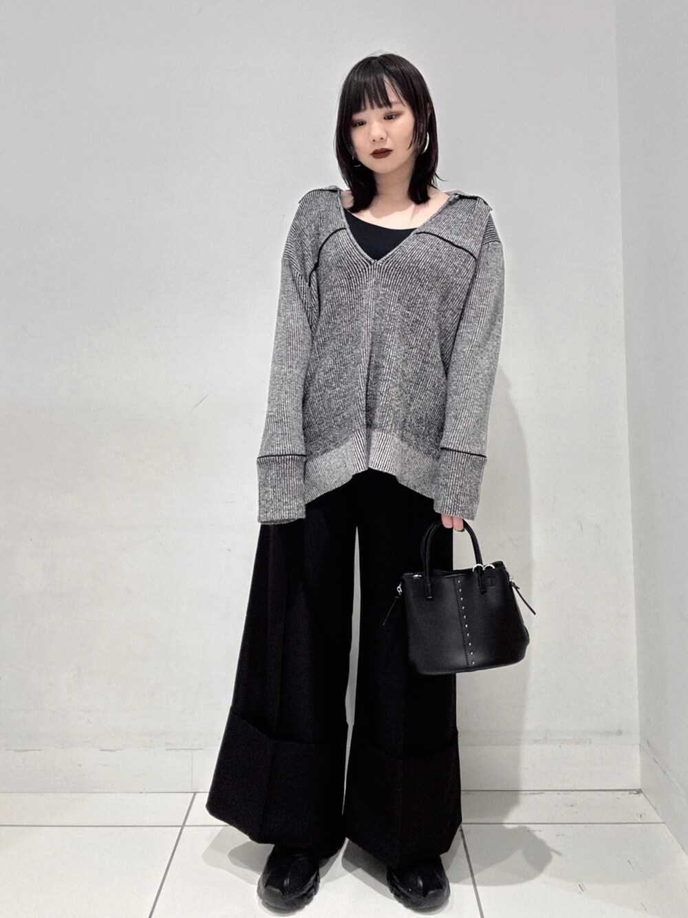 ブラック系のニット/セーター、ブラック系のその他パンツ、ブラック系のスニーカーを着用したレディースの秋コーディネートの2枚目の写真