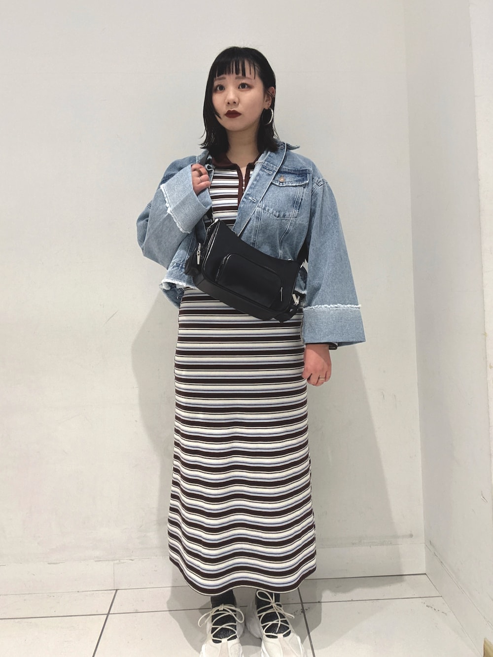 ブラウン系のワンピース、ブルー系のデニムジャケット、ホワイト系のスニーカーを着用したレディースの春コーディネートの3枚目の写真