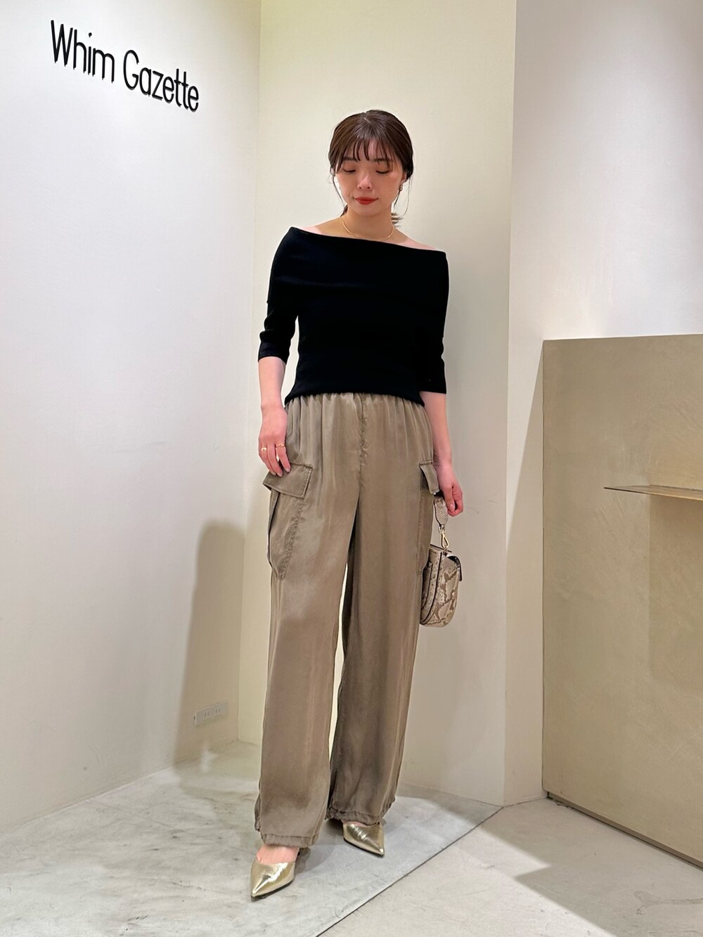 ブラック系のニット/セーター、ゴールド系のパンプス、ゴールド系のチョーカーを着用したレディースの春コーディネートの5枚目の写真