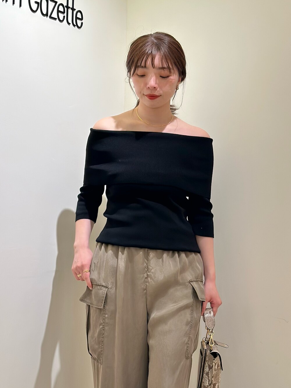 ブラック系のニット/セーター、ゴールド系のパンプス、ゴールド系のチョーカーを着用したレディースの春コーディネートの4枚目の写真