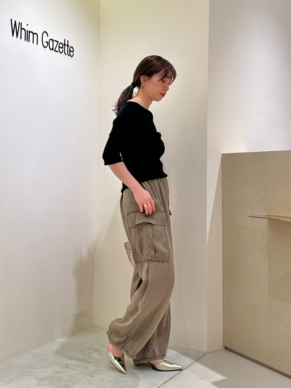ブラック系のニット/セーター、ゴールド系のパンプス、ゴールド系のチョーカーを着用したレディースの春コーディネートの3枚目の写真