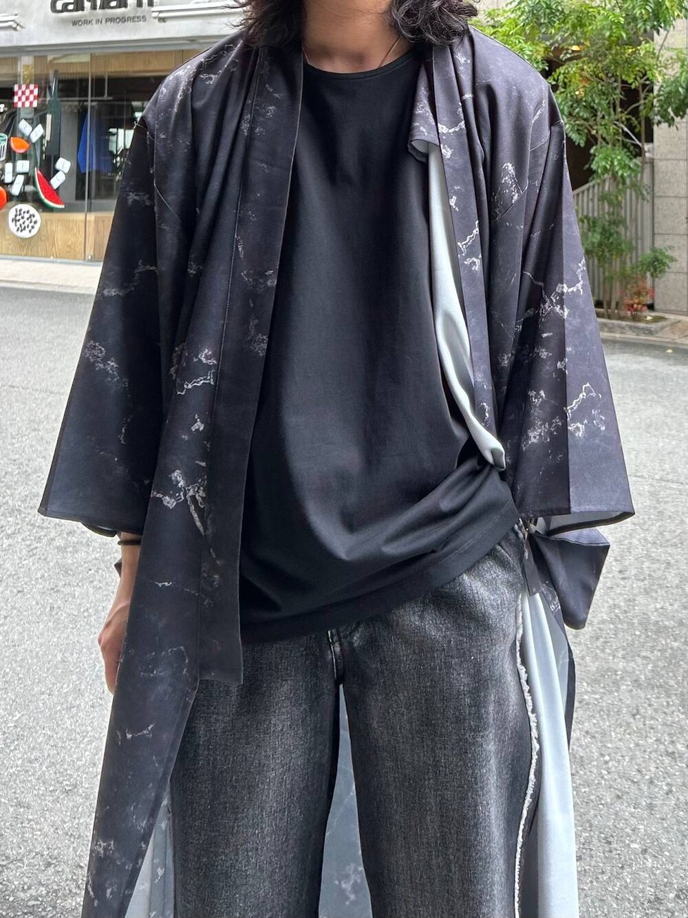 ブラック系のデニムパンツ、ブラック系のサンダル、ブラック系のTシャツ/カットソーを着用したメンズの夏コーディネートの2枚目の写真