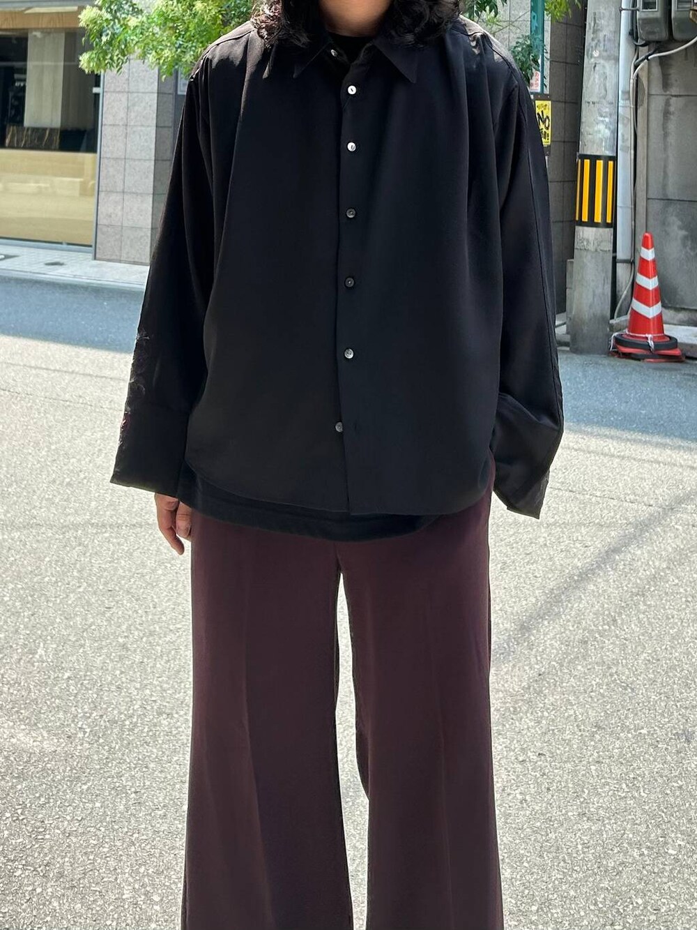 レッド系のスラックス、ブラック系のTシャツ/カットソー、ブラック系のドレスシューズを着用したメンズの夏コーディネートの2枚目の写真