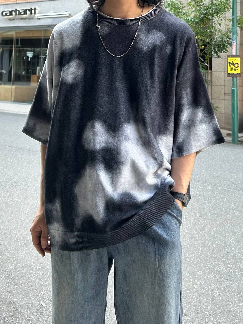 ブルー系のデニムパンツ、ブラック系のドレスシューズ、ブラック系のニット/セーターを着用したメンズの春コーディネートの2枚目の写真