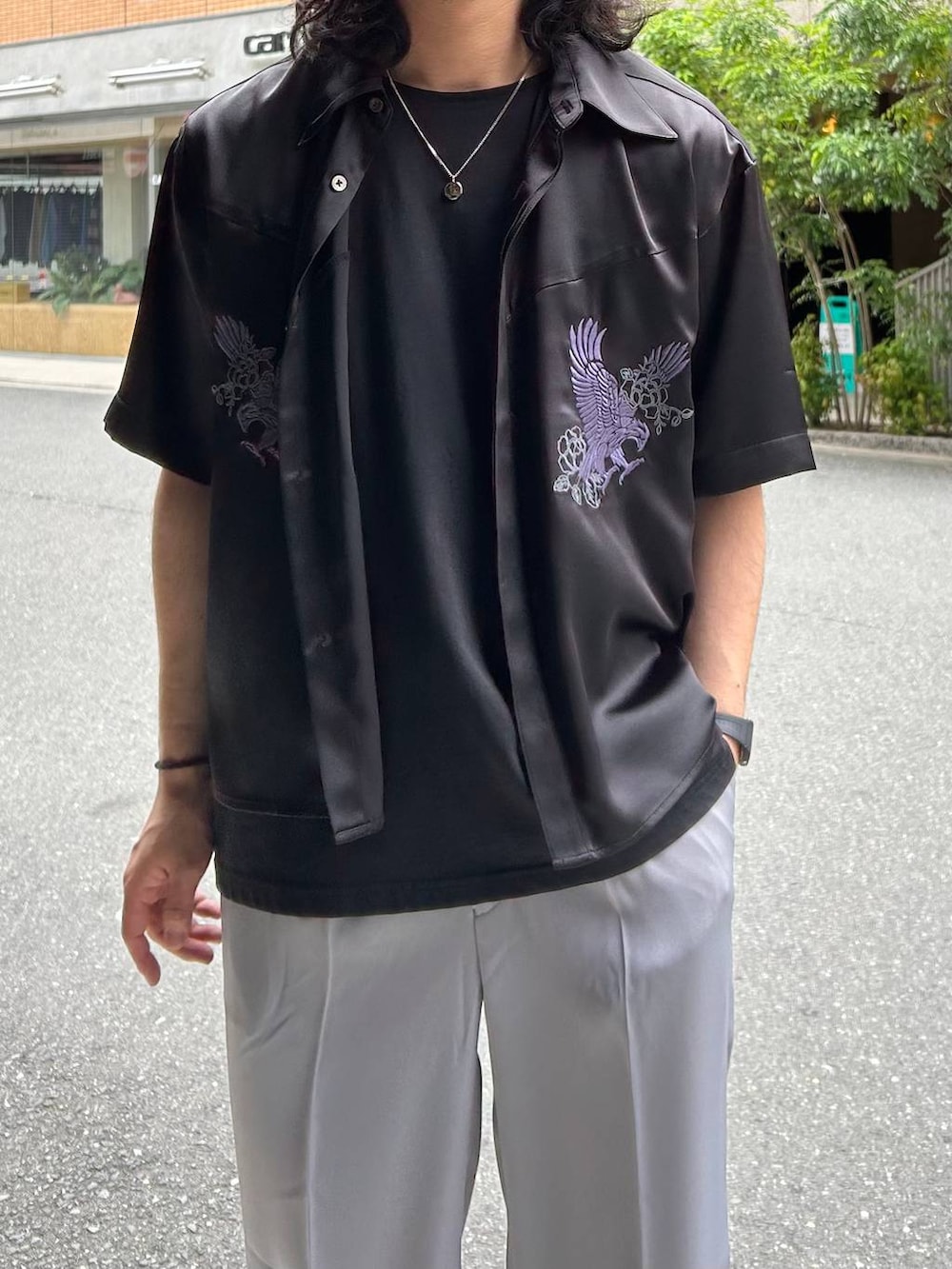 グレー系のスラックス、ブラック系のドレスシューズ、ブラック系のTシャツ/カットソーを着用したメンズの春コーディネートの2枚目の写真