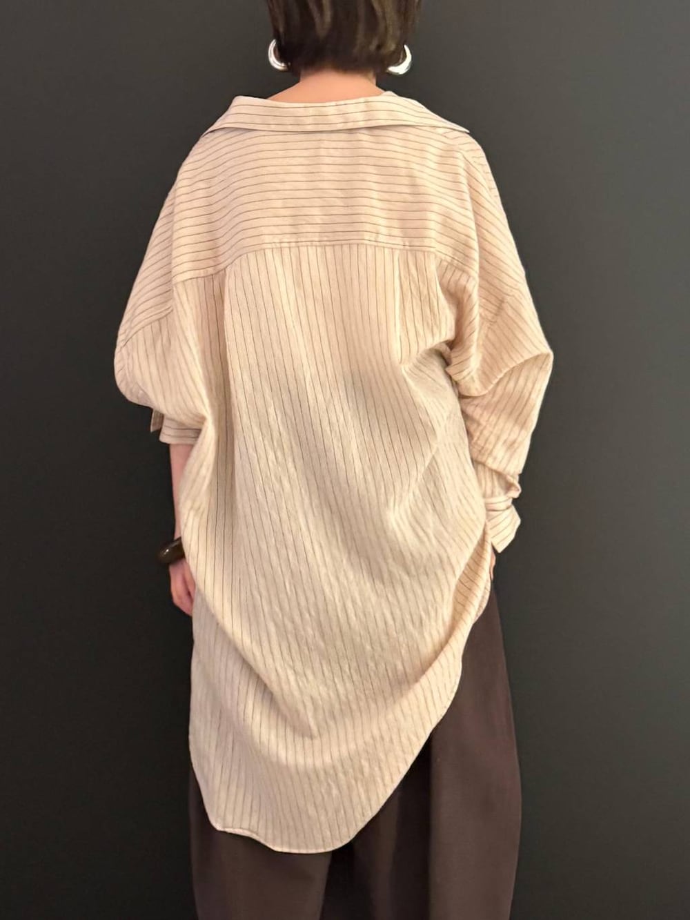 ブラウン系のその他パンツ、ベージュ系のシャツ/ブラウス、シルバー系のピアス(両耳用)を着用したレディースの夏コーディネートの4枚目の写真