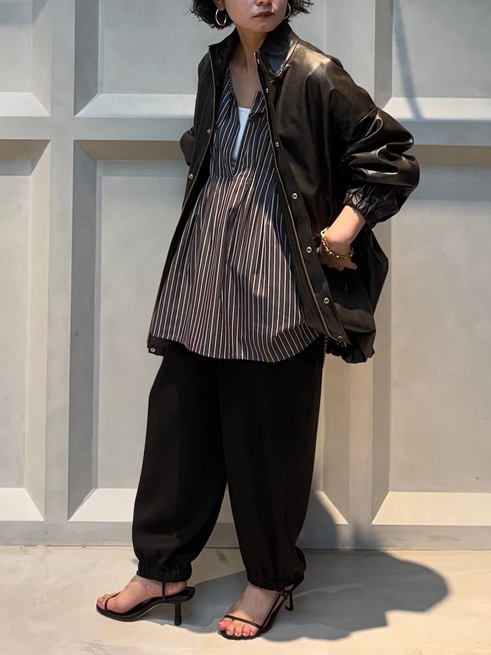 ホワイト系のキャミソール、ブラウン系のブルゾン、ブラウン系のその他パンツを着用したレディースの秋コーディネートの2枚目の写真