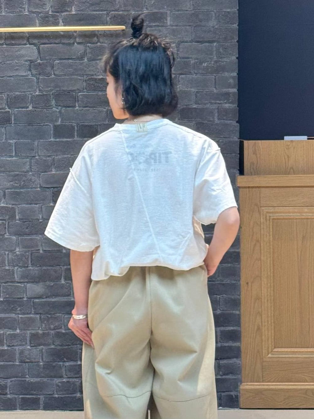 ブラウン系のその他パンツ、シルバー系のバングル/リストバンド、シルバー系のピアス(両耳用)を着用したレディースの冬コーディネートの3枚目の写真
