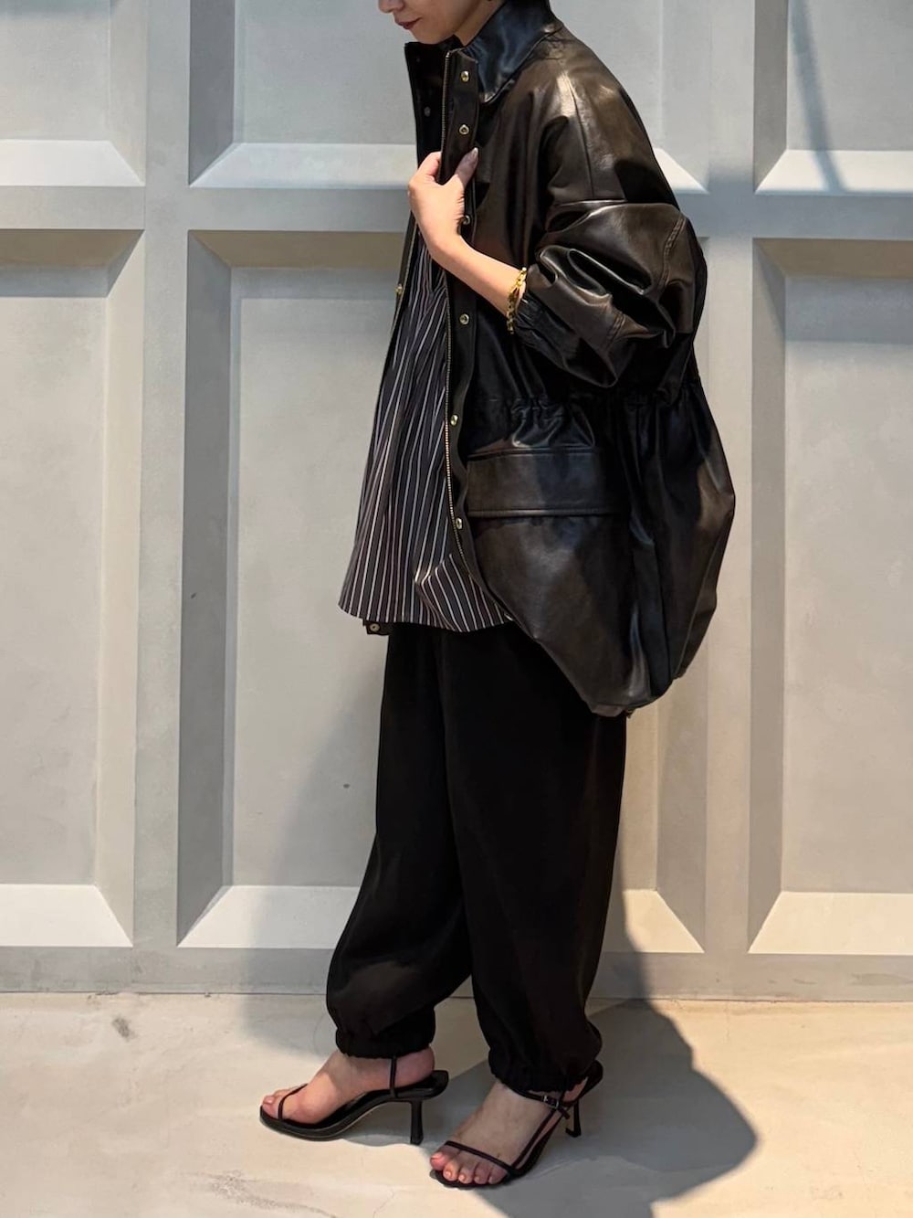 ホワイト系のキャミソール、ブラウン系のブルゾン、ブラウン系のその他パンツを着用したレディースの秋コーディネートの4枚目の写真