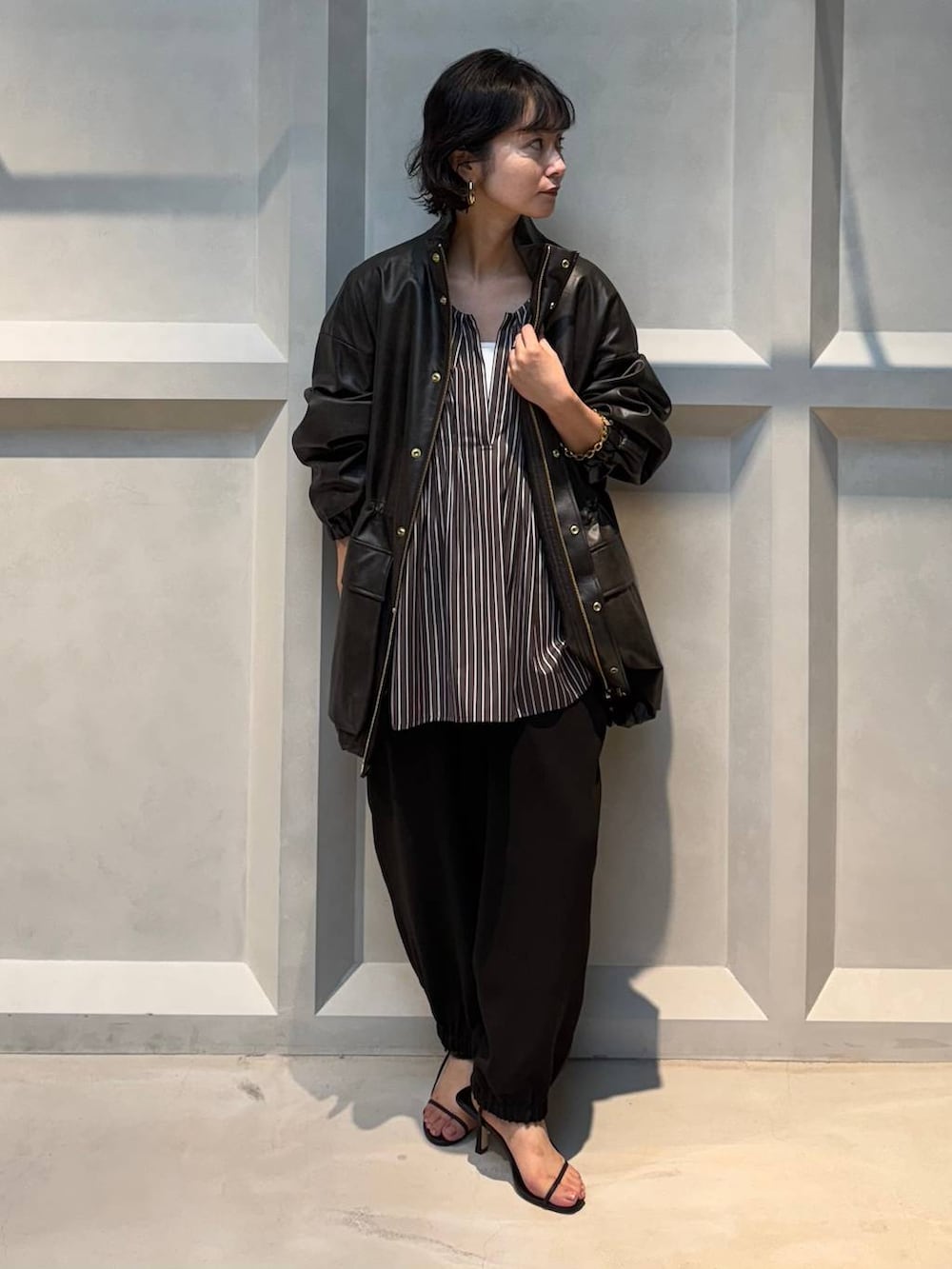 ホワイト系のキャミソール、ブラウン系のブルゾン、ブラウン系のその他パンツを着用したレディースの秋コーディネートの3枚目の写真