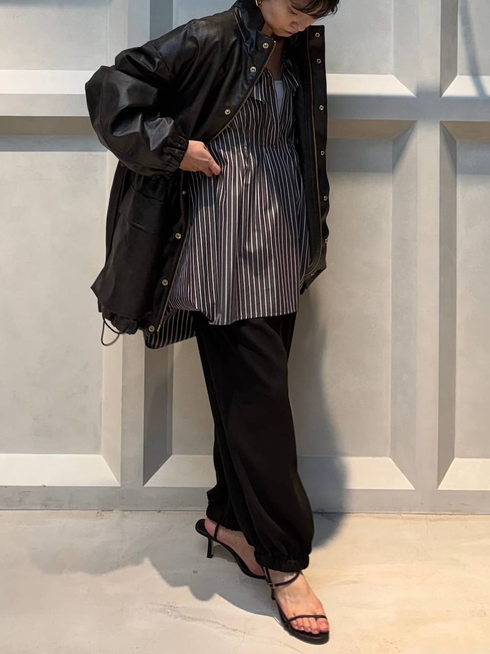 ホワイト系のキャミソール、ブラウン系のブルゾン、ブラウン系のその他パンツを着用したレディースの秋コーディネートの5枚目の写真