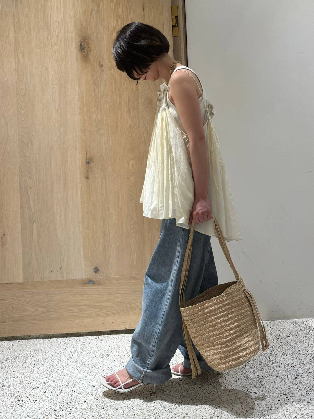 ホワイト系のタンクトップ、ホワイト系のキャミソール、ブルー系のデニムパンツを着用したレディースの春コーディネートの2枚目の写真