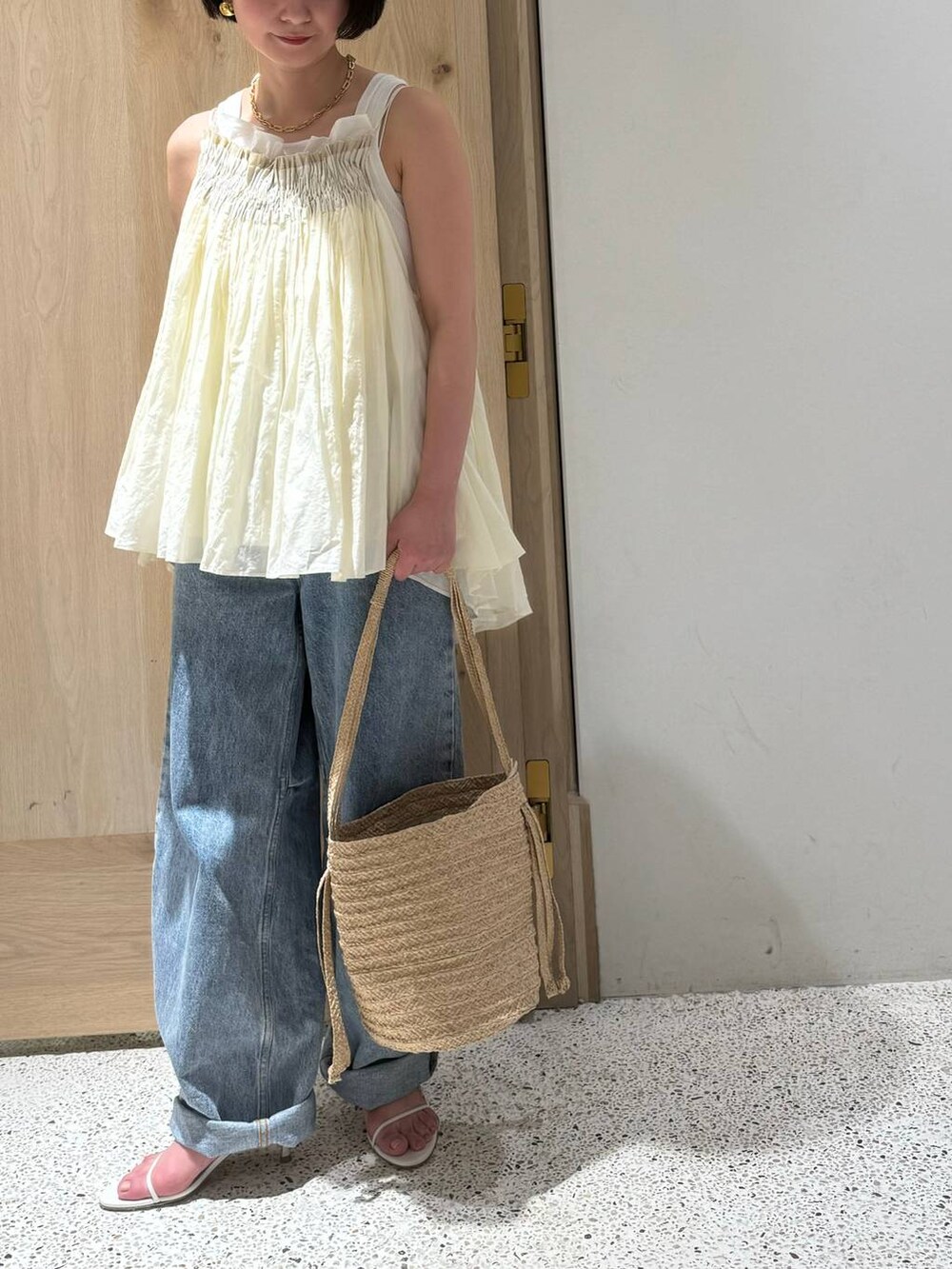 ホワイト系のタンクトップ、ホワイト系のキャミソール、ブルー系のデニムパンツを着用したレディースの春コーディネートの4枚目の写真