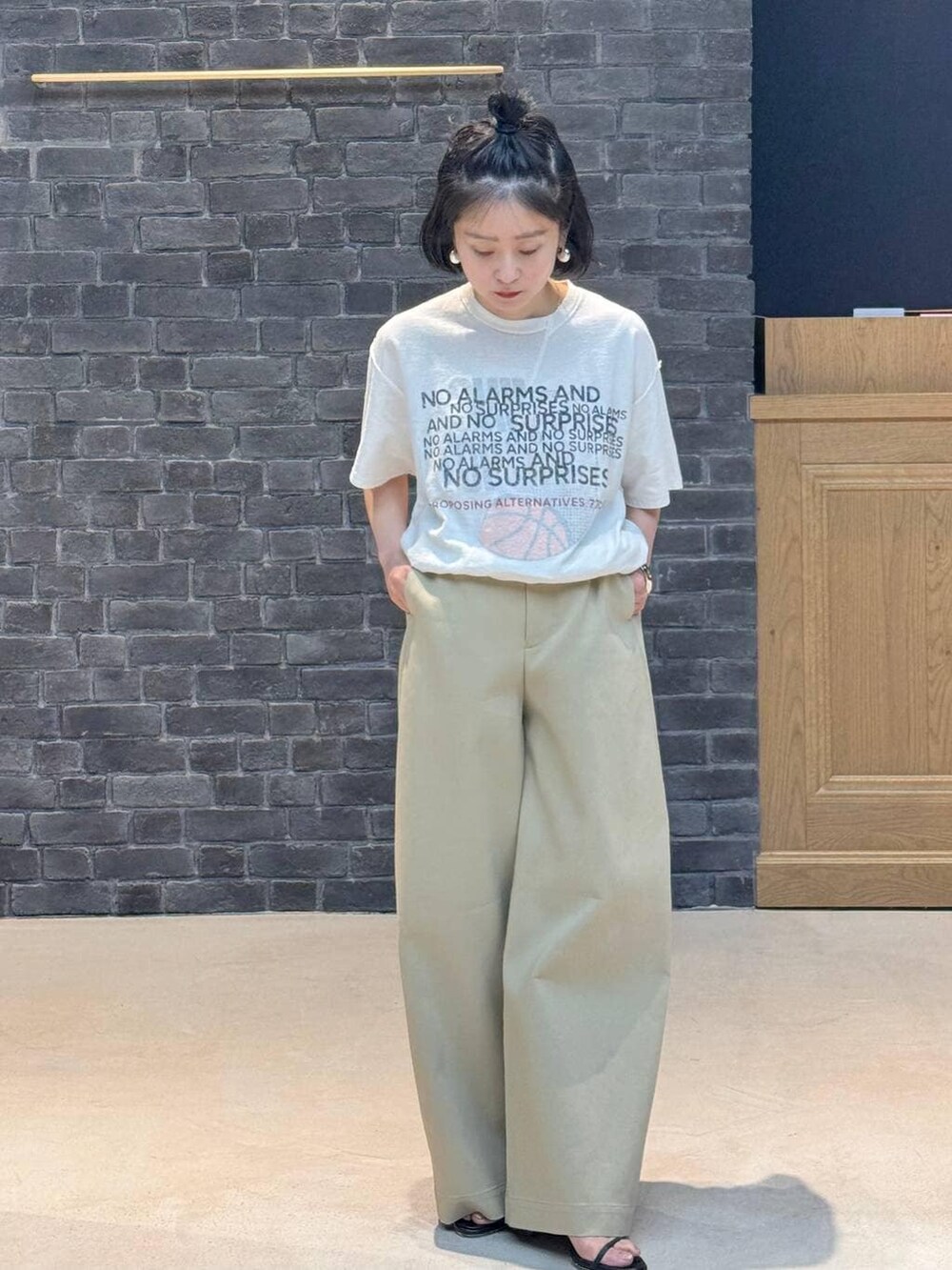 ブラウン系のその他パンツ、シルバー系のバングル/リストバンド、シルバー系のピアス(両耳用)を着用したレディースの冬コーディネートの2枚目の写真