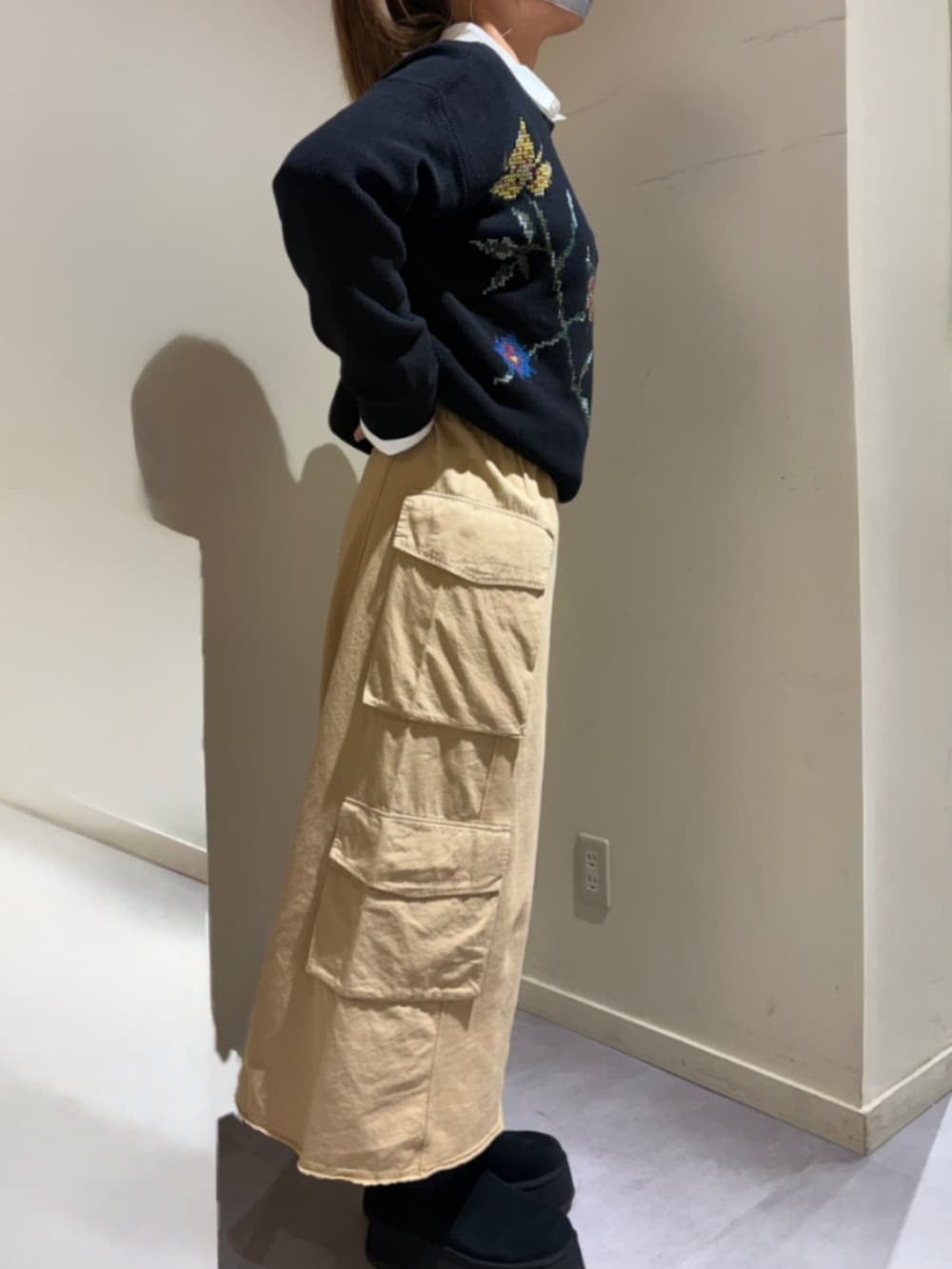 ブラック系のニット/セーター、ブラウン系のスカートを着用したレディースの冬コーディネートの2枚目の写真