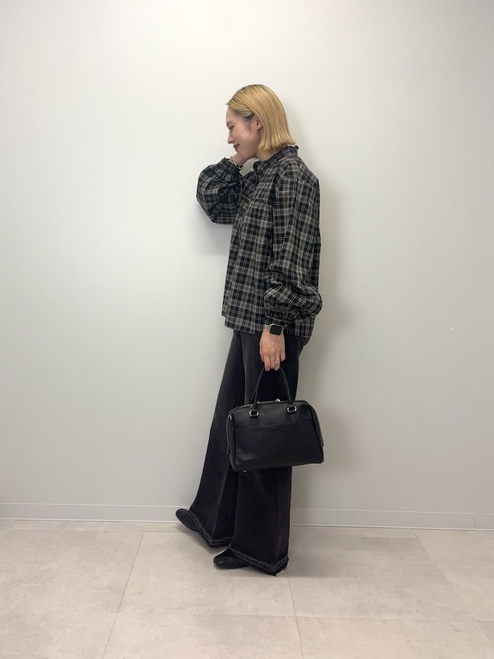 ブラック系のシャツ/ブラウス、ブラック系のデニムパンツ、ブラック系のボストンバッグを着用したレディースの秋コーディネートの2枚目の写真