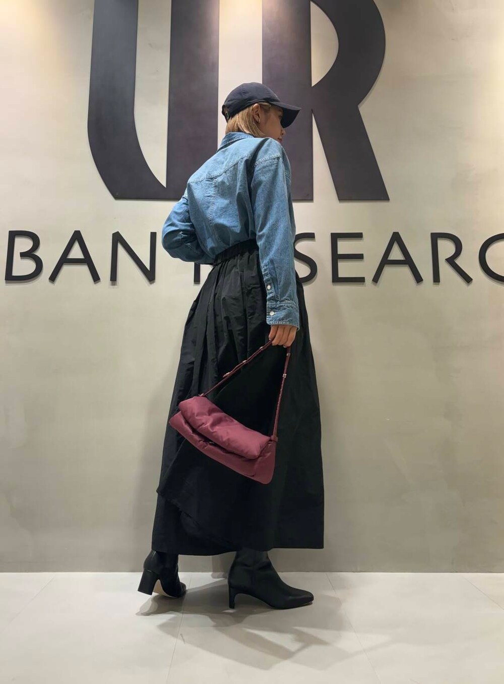 ブルー系のTシャツ/カットソー、ブラック系のスカート、ブルー系のキャップを着用したレディースの夏コーディネートの2枚目の写真