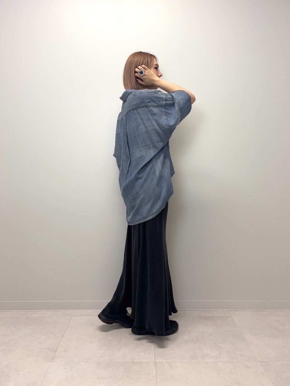 ブルー系のシャツ/ブラウス、ブラック系のスカート、ブラック系のスニーカーを着用したレディースの春コーディネートの2枚目の写真