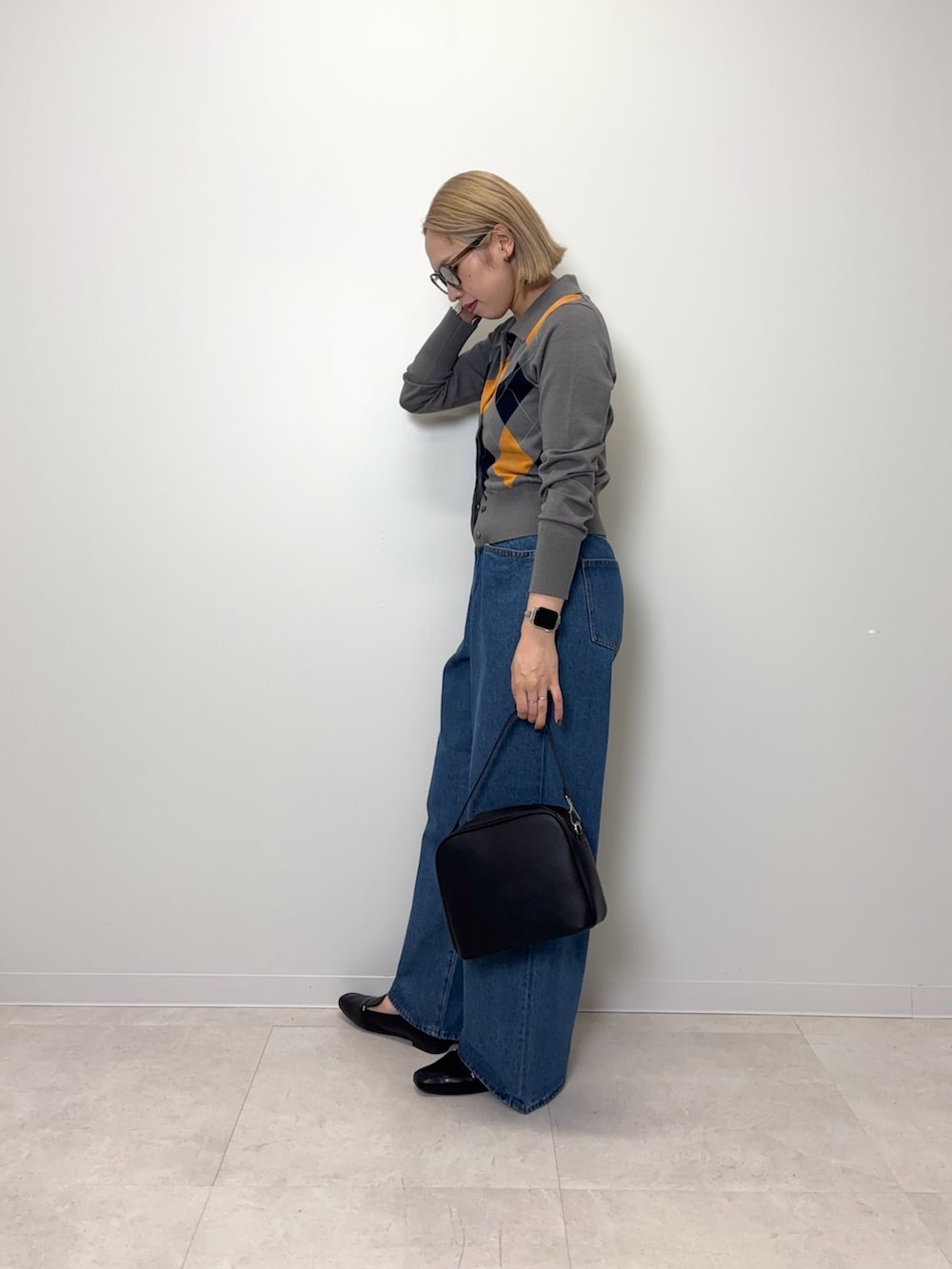 グレー系のカーディガン/ボレロ、ブルー系のデニムパンツ、ブラック系のショルダーバッグを着用したレディースの秋コーディネートの2枚目の写真