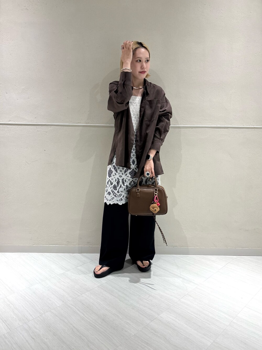 ブラウン系のシャツ/ブラウス、ブラック系のその他パンツ、ブラウン系のボストンバッグを着用したレディースの夏コーディネートの4枚目の写真