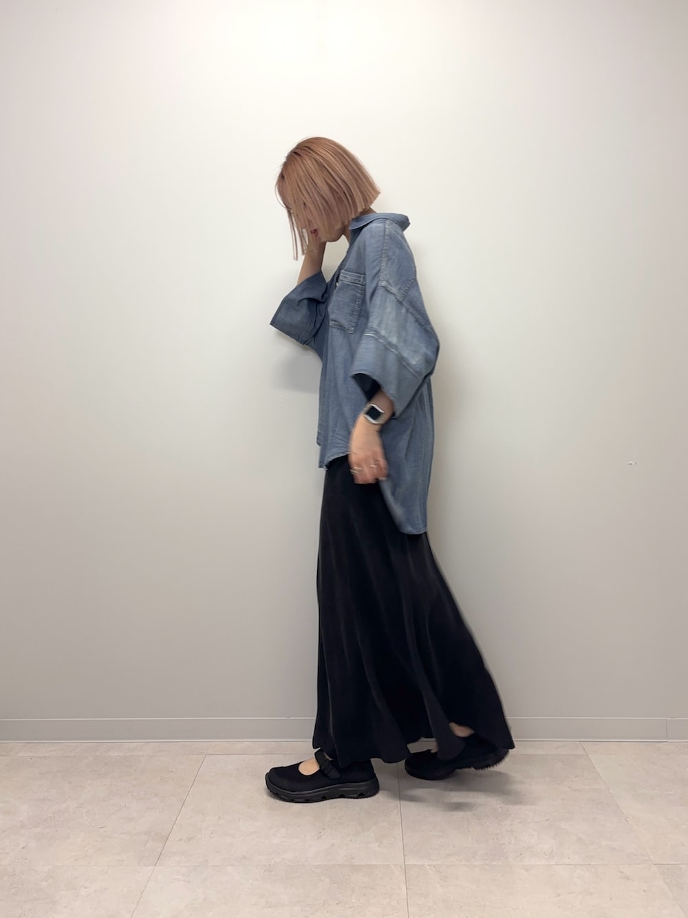 ブルー系のシャツ/ブラウス、ブラック系のスカート、ブラック系のスニーカーを着用したレディースの春コーディネートの4枚目の写真