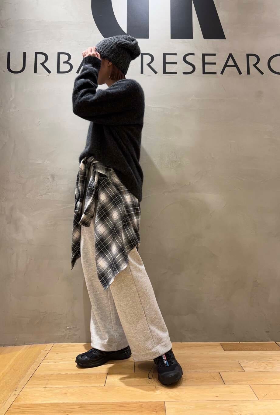 グレー系のニット/セーター、グレー系のその他パンツ、ブラック系のシャツ/ブラウスを着用したレディースの秋コーディネートの2枚目の写真