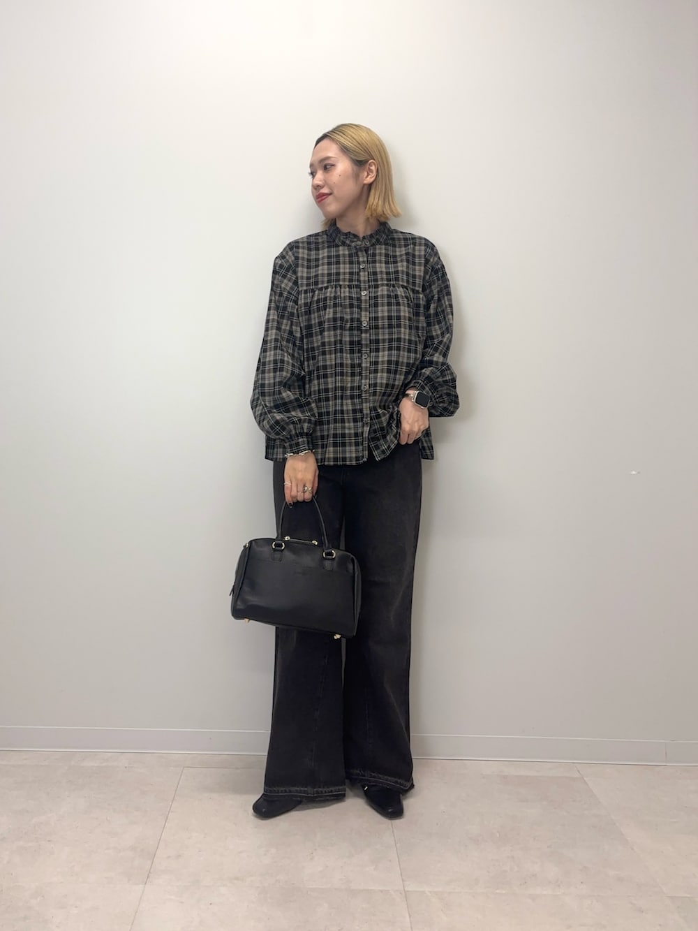 ブラック系のシャツ/ブラウス、ブラック系のデニムパンツ、ブラック系のボストンバッグを着用したレディースの秋コーディネートの4枚目の写真