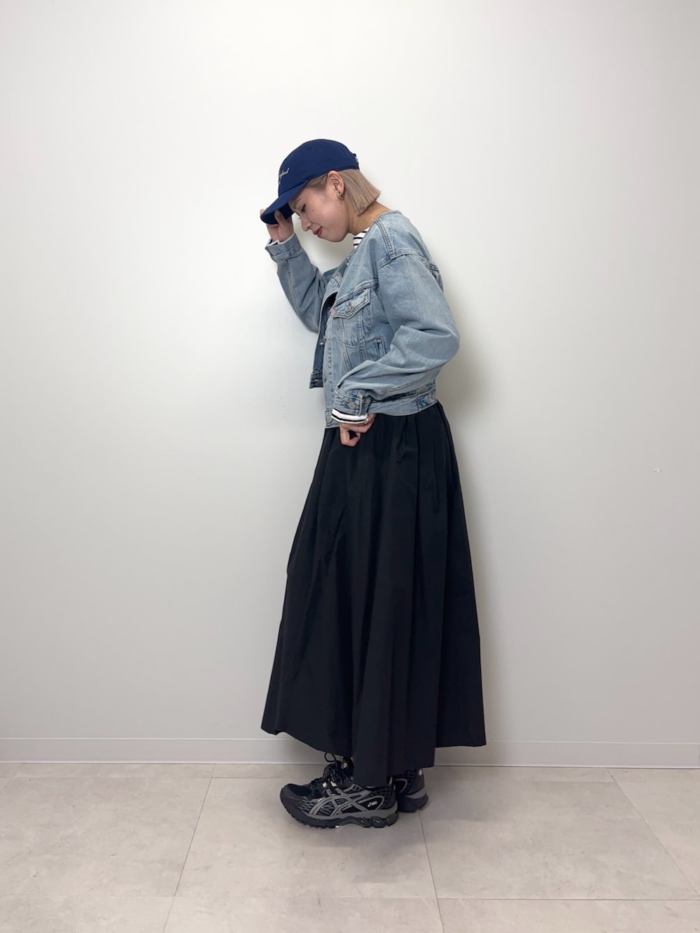 ブルー系のデニムジャケット、ブラック系のTシャツ/カットソー、ブラック系のスカートを着用したレディースの春コーディネートの2枚目の写真