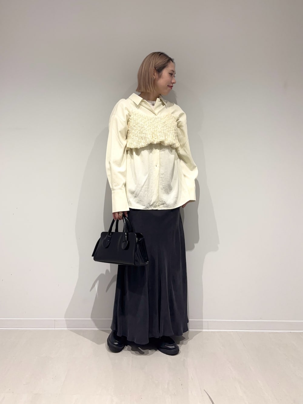 ブラック系のスカート、ブラック系のボストンバッグ、ホワイト系のシャツ/ブラウスを着用したレディースの春コーディネートの4枚目の写真