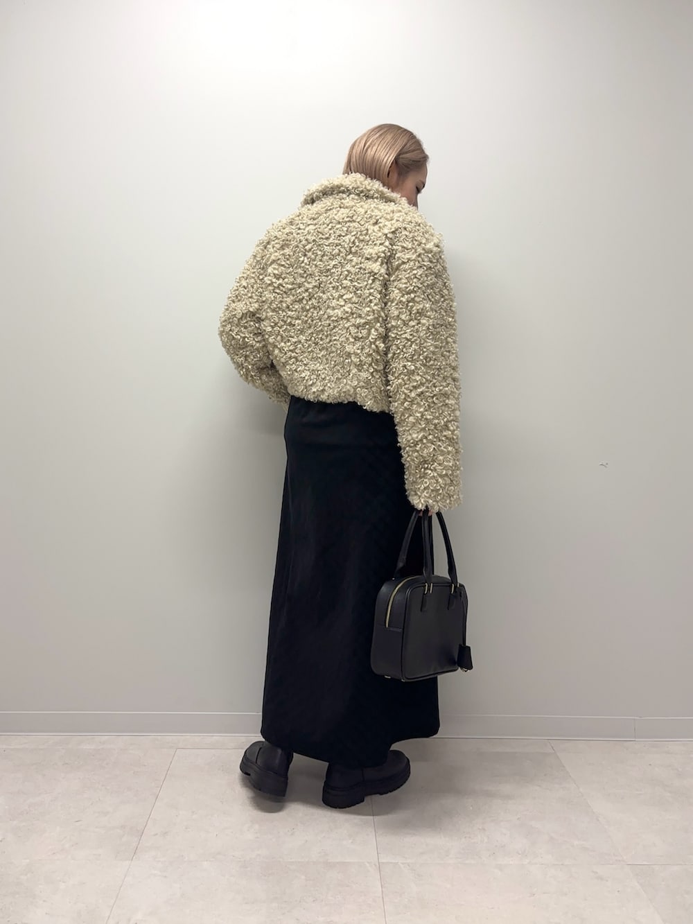 ホワイト系のニット/セーター、ブラック系のワンピース、ホワイト系のその他アウターを着用したレディースの冬コーディネートの3枚目の写真