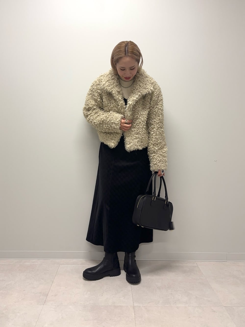 ホワイト系のニット/セーター、ブラック系のワンピース、ホワイト系のその他アウターを着用したレディースの冬コーディネートの7枚目の写真