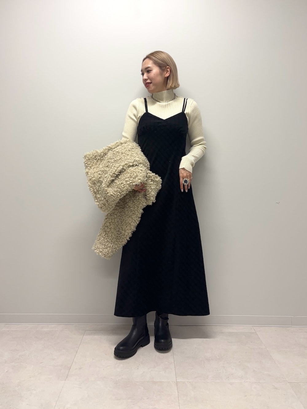 ホワイト系のニット/セーター、ブラック系のワンピース、ホワイト系のその他アウターを着用したレディースの冬コーディネートの6枚目の写真